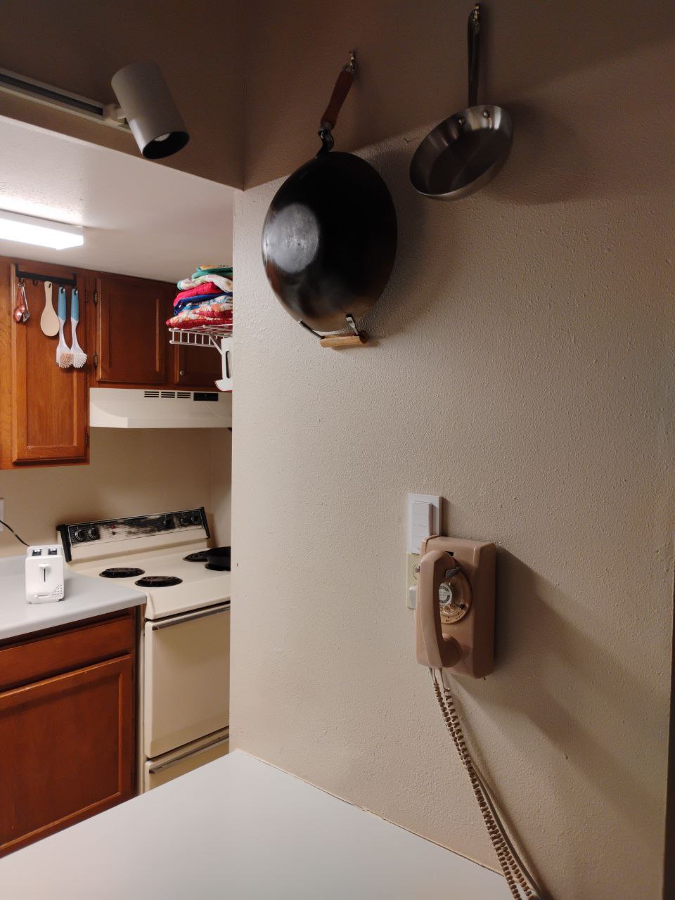 Phone mounted on the wall in my kitchen underneath my wok hooks.